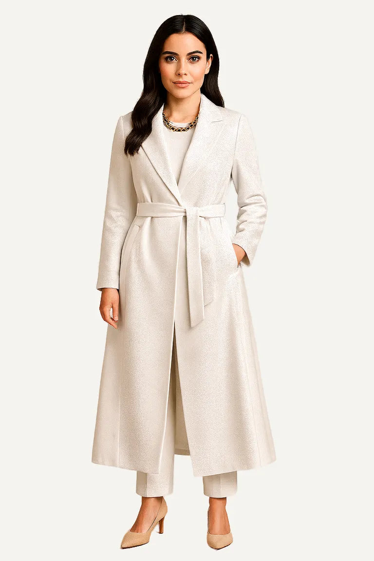WAROODI Celeste Prestige Belted Coat in Ivory Pearl – longline shimmer coat with belt, pockets, and modest tailored silhouette.