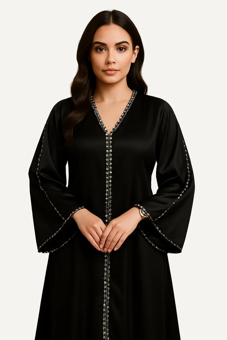WAROODI Layali Embellished Satin Kaftan in Midnight Black – crystal-trimmed neckline and flowing silhouette”
“Model wearing Layali Satin Kaftan – elegant black embellished kaftan by WAROODI