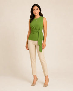 Olive green sleeveless knot-detail top by WAROODI with tailored cream trousers, three-quarter view