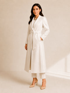 Celeste Prestige Belted Coat in Ivory Pearl three-quarter view, showing the relaxed belted fit, soft shimmer finish, notched lapel collar, and refined modest outerwear styling.
