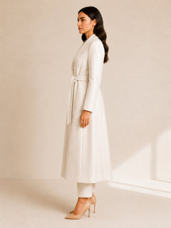 Celeste Prestige Belted Coat in Ivory Pearl side view, full-length belted modest coat with long sleeves, flowing structure, side pocket detail, and elegant shimmer-textured cotton blend.