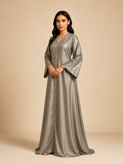 Layali Satin Embellished Kaftan by WAROODI three-quarter view, showing the smooth satin drape, crystal embellished neckline, full front panel detail, wide sleeves, and elegant modest luxury styling.