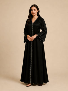 Layali Black Satin Embellished Kaftan by WAROODI three-quarter view, showing the premium satin sheen, hand-embellished crystal neckline, front panel detail, wide sleeves, and elegant modest luxury styling.