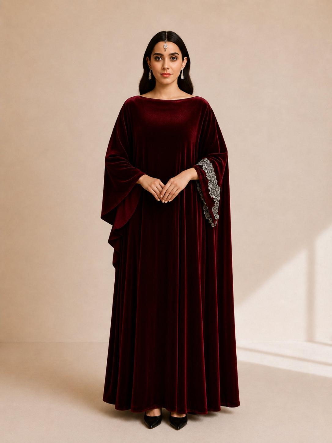 Malika Velvet Kaftan by WAROODI front view, deep burgundy full-length luxury kaftan with boat neckline, wide sleeves, crystal-embellished cuffs, and elegant modest evening silhouette.
