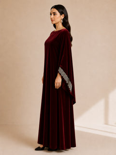 Malika Velvet Kaftan by WAROODI side view, deep burgundy velvet kaftan with soft flowing structure, elegant full-length silhouette, wide sleeves, and sophisticated evening styling.