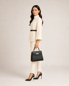 WAROODI ivory high-neck cape top with slim trousers and black handbag, side view