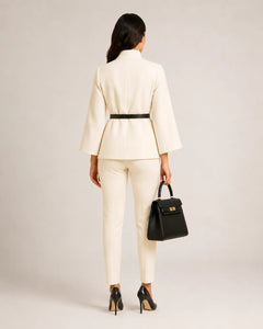 Back view of WAROODI Valeria High-Neck Cape Co-ord Set in ivory cream with wide sleeves and black belt
